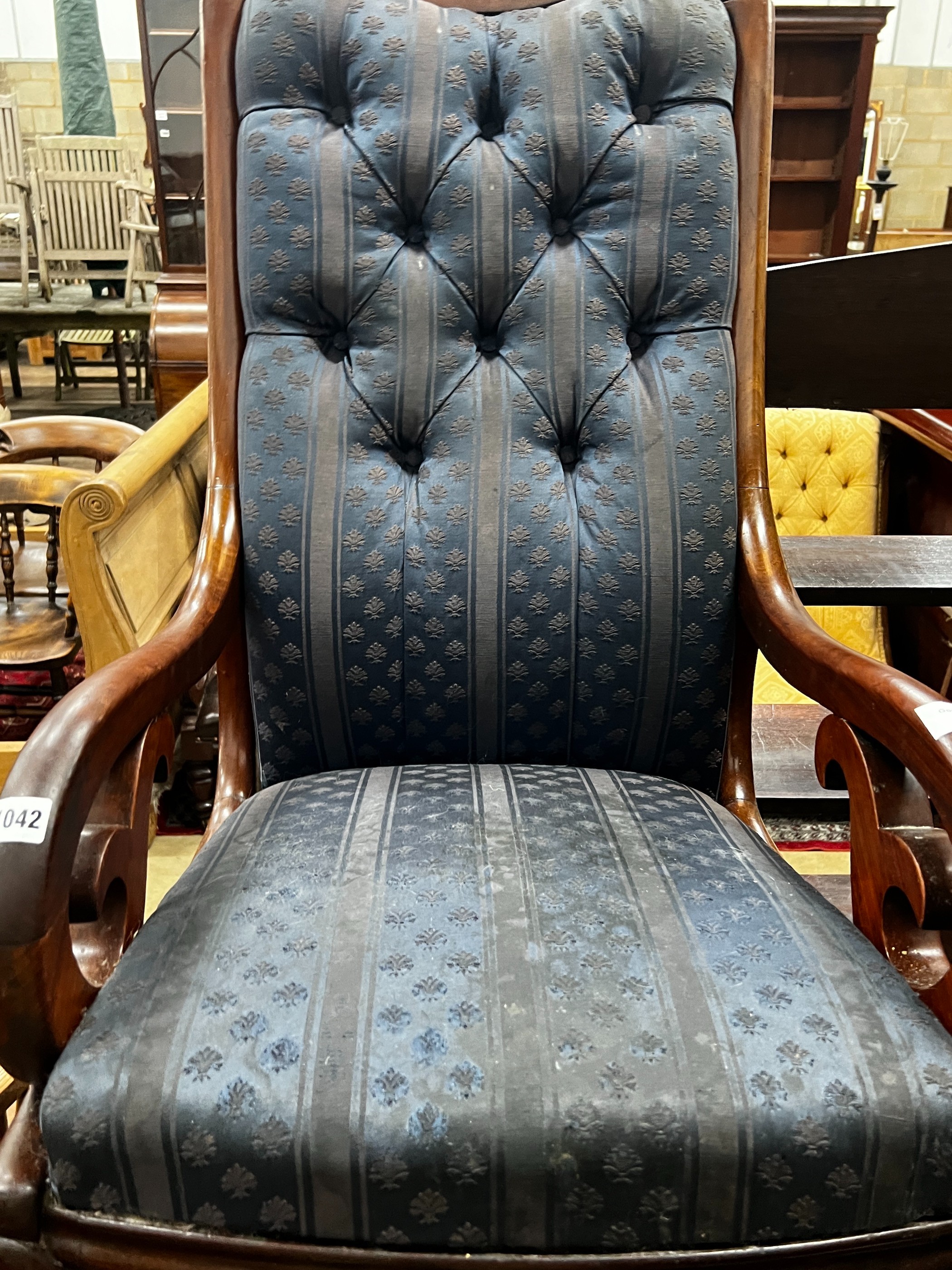 A Victorian carved mahogany upholstered rocking elbow chair, width 53cm, depth 76cm, height 104cm